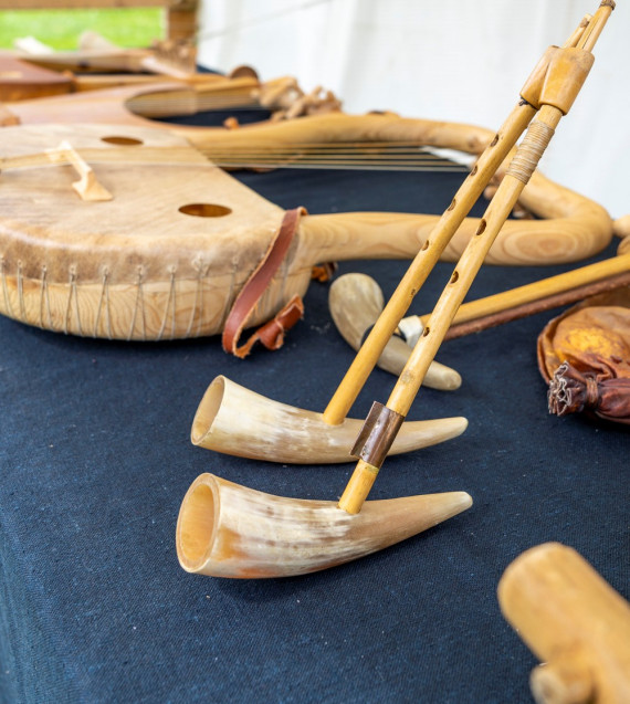 Antike Musikinstrumente auf einem Tisch: 2 Flöten im Vordergrund, lyra im hintergrund