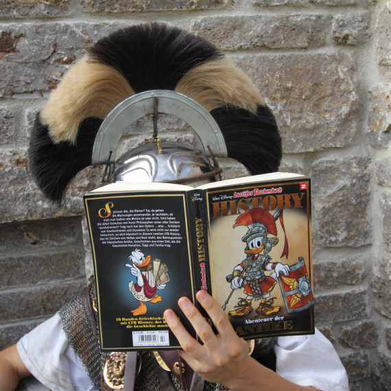 Römischer Legionär beim Lesen in einem &quot;Lustigen Taschenbuch&quot;.